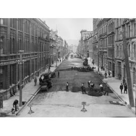 Elevated view of Victoria Street with alsphatic concrete paving in progress, number of workmen and equipment, Victoria Street, March 1926
