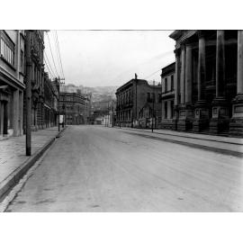 Shows Farish Street intersection. Town Hall at right of image, wooden dwellings on hillside in background. Photograph of new asphaltic concrete surface, Wakefield Street, March 1926