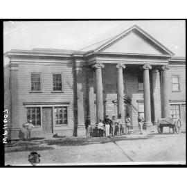Group of men standing outside the Oddfellows Hall, foundation stone laid in 1859