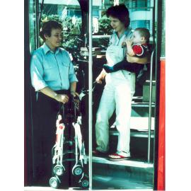 Bus driver aiding passenger with pram